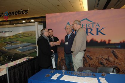 Andrew Hecht, editor of Canadian Hog Journal, (second from left), visits with delegates.